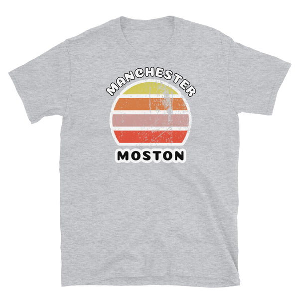 Distressed style abstract retro sunset graphic in yellow, orange, pink and scarlet stripes. The name of Manchester is displayed at the top wrapped around the sunset. Below the retro sunset design is the famous Manchester place name of Moston on this light grey cotton t-shirt.