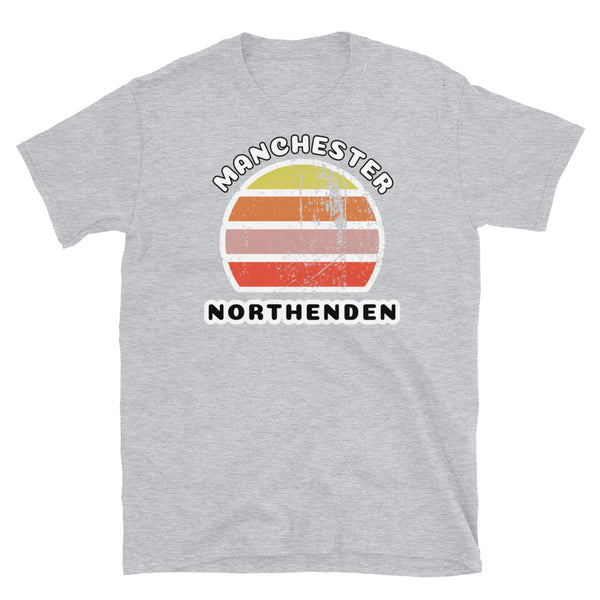 Distressed style abstract retro sunset graphic in yellow, orange, pink and scarlet stripes. The name of Manchester is displayed at the top wrapped around the sunset. Below the retro sunset design is the famous Manchester place name of Northenden on this light grey cotton t-shirt.