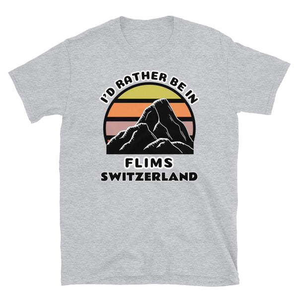 Flims Switzerland vintage sunset mountain scene in silhouette, surrounded by the words I'd Rather Be In on top and Flims, Switzerland below on this light grey cotton ski and mountain themed t-shirt