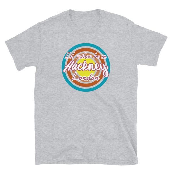 Hackney urban vintage style graphic in turquoise, orange, pink and yellow concentric circles with the slogan I'd rather be in Hackney London across the front in retro style font on this light grey cotton t-shirt