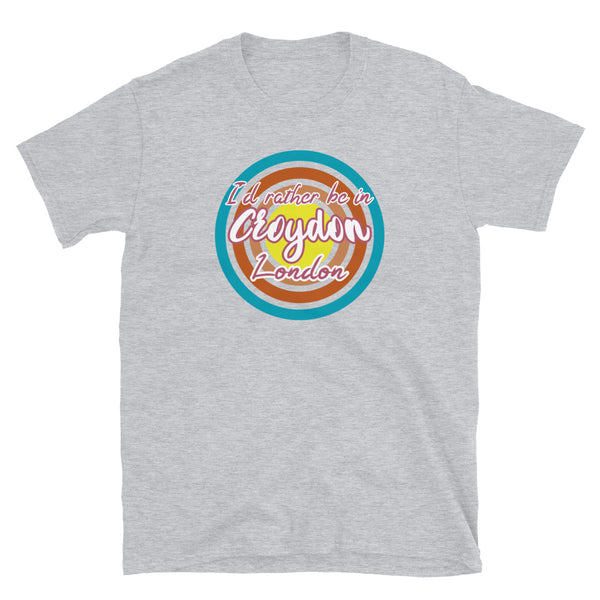 Croydon urban city vintage style graphic in turquoise, orange, pink and yellow concentric circles with the slogan I'd rather be in Croydon London across the front in retro vintage style font on this light grey cotton t-shirt