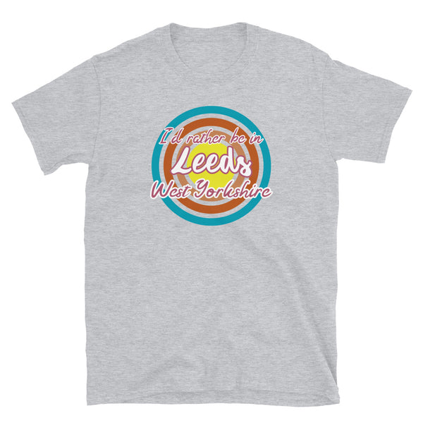 Leeds West Yorkshire urban city vintage style graphic in turquoise, orange, pink and yellow concentric circles with the slogan I'd rather be in Leeds West Yorkshire across the front in retro style font on this light grey cotton t-shirt