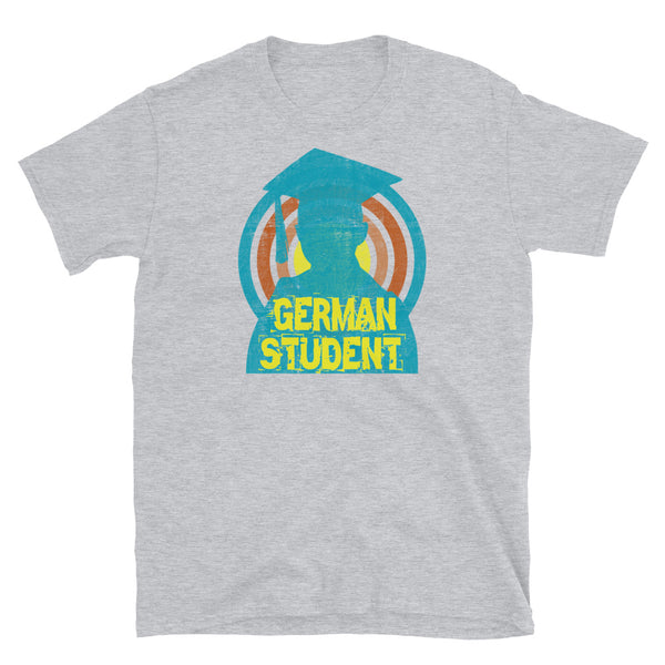 German Student novelty tee with a distressed style turquoise silhouetted student against a concentric circular design and the words German Student in bold yellow font on this light grey cotton fun graphic t-shirt by BillingtonPix