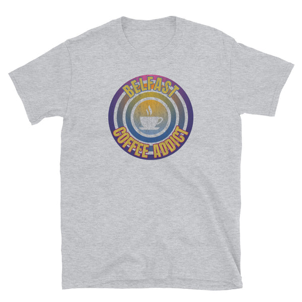 Concentric circular design of retro 80s metallic colours and the slogan Belfast Coffee Addict with a coffee cup silhouette in the centre. Distressed and dirty style image for a vintage Retrowave look on this light grey cotton t-shirt by BillingtonPix