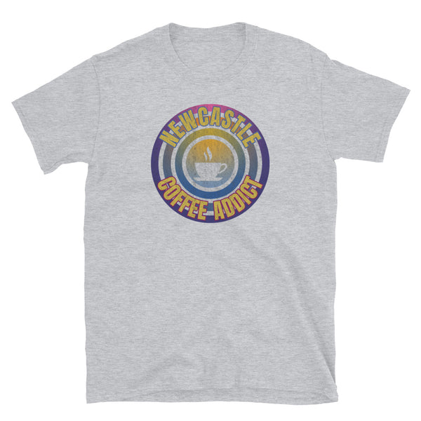 Concentric circular design of retro 80s metallic colours and the slogan Newcastle Coffee Addict with a coffee cup silhouette in the centre. Distressed and dirty style image for a vintage Retrowave look on this light grey cotton t-shirt by BillingtonPix