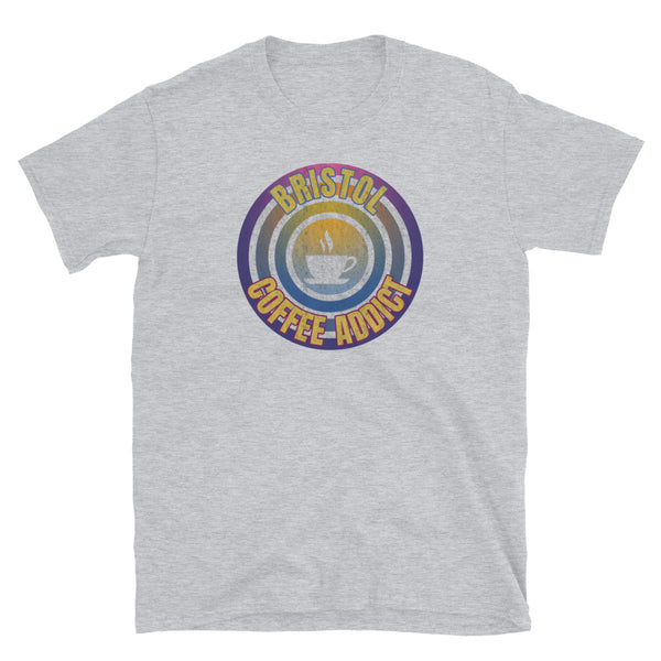 Concentric circular design of retro 80s metallic colours and the slogan Bristol Coffee Addict with a coffee cup silhouette in the centre. Distressed and dirty style image for a vintage Retrowave look on this light grey cotton t-shirt by BillingtonPix