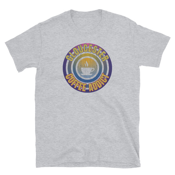 Concentric circular design of retro 80s metallic colours and the slogan Gloucester Coffee Addict with a coffee cup silhouette in the centre. Distressed and dirty style image for a vintage Retrowave look on this light grey cotton t-shirt by BillingtonPix