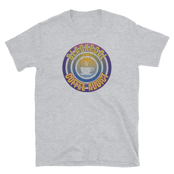 Concentric circular design of retro 80s metallic colours and the slogan Blackpool Coffee Addict with a coffee cup silhouette in the centre. Distressed and dirty style image for a vintage Retrowave look on this light grey cotton t-shirt by BillingtonPix