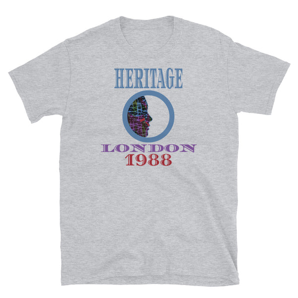 Graphic t-shirt with a patterned profile face in abstract design, tones of blue, green, purple, red, in circular format, with the words Heritage London 1988 in blue, purple and red on this light grey cotton t-shirt by BillingtonPix