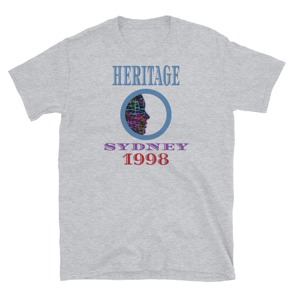 Graphic t-shirt with a patterned profile face in abstract design, tones of blue, green, purple, red, in circular format, with the words Heritage Sydney 1998 in blue, purple and red on this light grey cotton t-shirt by BillingtonPix