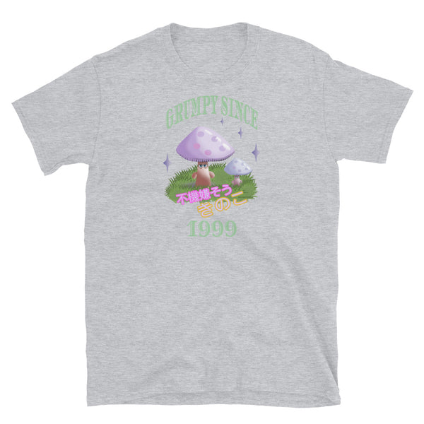 Cute Japanese Kawaii style graphic tee with a cottagecore style theme of woodland mushrooms. Muted tones in a retro vintage 90s Japanese style in pale pinks, mauves and green. These are grumpy mushrooms and the slogan Grumpy Since 1999 and 不機嫌そうなキノコ describe this light grey cotton t-shirt by BillingtonPix