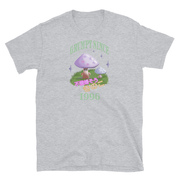 Cute Japanese Kawaii style graphic tee with a cottagecore style theme of woodland mushrooms. Muted tones in a retro vintage 90s Japanese style in pale pinks, mauves and green. These are grumpy mushrooms and the slogan Grumpy Since 1996 and 不機嫌そうなキノコ describe this light grey cotton t-shirt by BillingtonPix