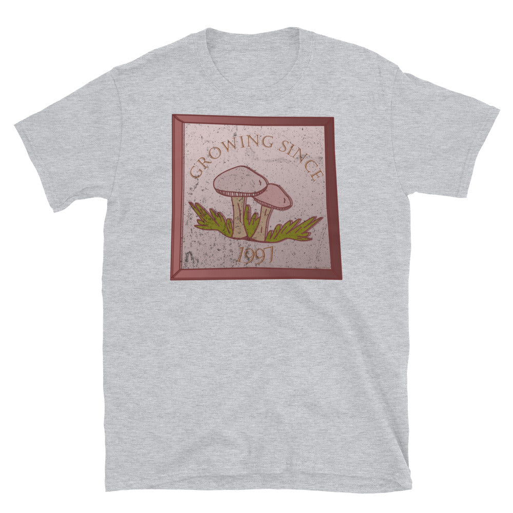 Growing since 1997 cute Goblincore style design with two mushrooms in muted tones and a glass framed effect with distressed look on this sport grey cotton t-shirt by BillingtonPix