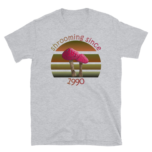 Shrooming since 1990 cute Goblincore style design with two red fly agaric mushrooms with distressed look against a multi-toned nature colour palette abstract vintage sunset design on this sport grey cotton t-shirt by BillingtonPix