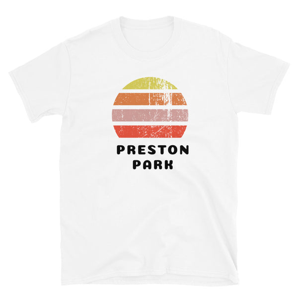 Features a distressed abstract retro sunset graphic in yellow, orange, pink and scarlet stripes rising up from the famous Brighton place name of Preston Park on this white t-shirt