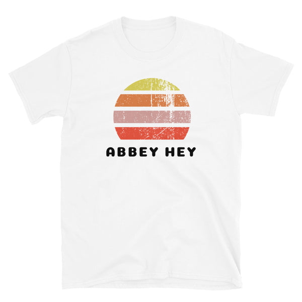 Distressed style abstract retro sunset graphic in yellow, orange, pink and scarlet stripes above the famous Manchester place name of Abbey Hey on this white cotton t-shirt