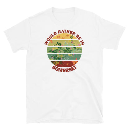 Cottagecore style floral and butterfly design within a Vintage Sunset abstract shape in tones of crimson, teal, green, mustard and yellow stripes with the slogan Would Rather Be in Somerset on this white cotton t-shirt by BillingtonPix